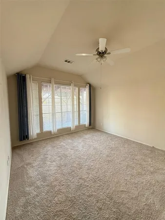 an empty room with windows and fan