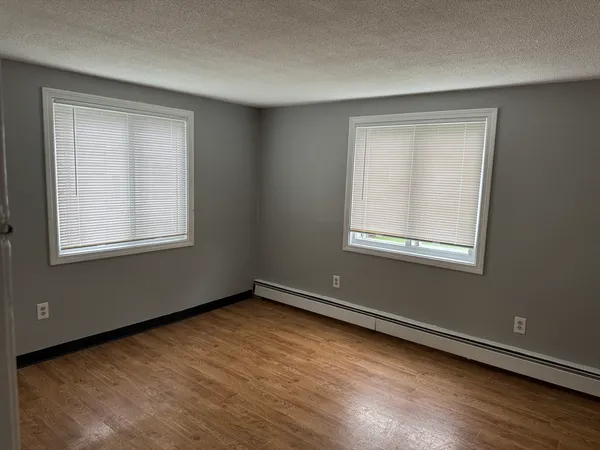 a view of a room with wooden floor and windows