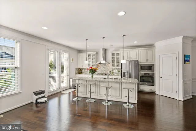 a large white kitchen with lots of counter space a sink and appliances
