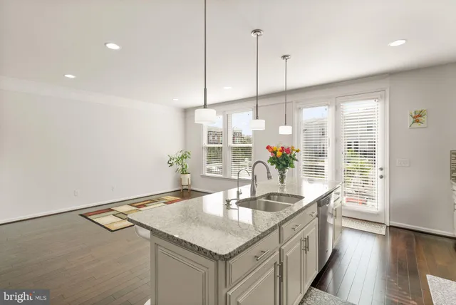 a kitchen with granite countertop a sink a counter top space and living room view