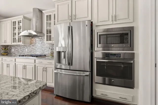 a kitchen with stainless steel appliances granite countertop a stove microwave and refrigerator