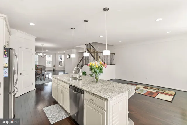 a kitchen with stainless steel appliances granite countertop a sink a stove and a wooden floors