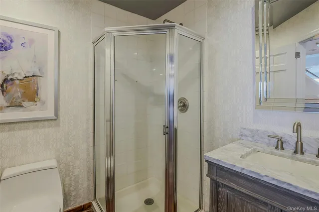 a bathroom with a granite countertop sink mirror and shower
