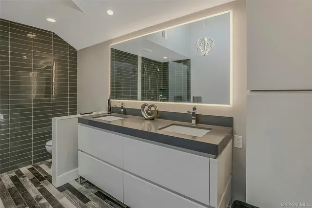 a bathroom with a granite countertop sink and a large mirror