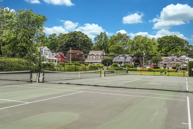 a view of a tennis ground with large trees
