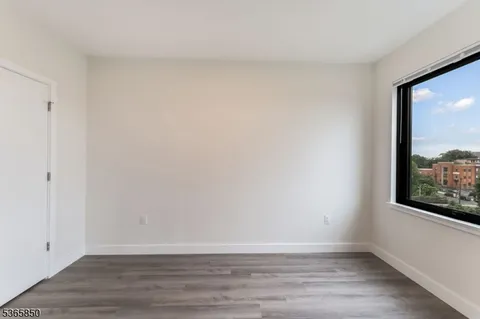 a view of a small space with wooden floor and a window