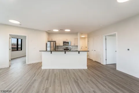 a view of kitchen with wooden floor and electronic appliances