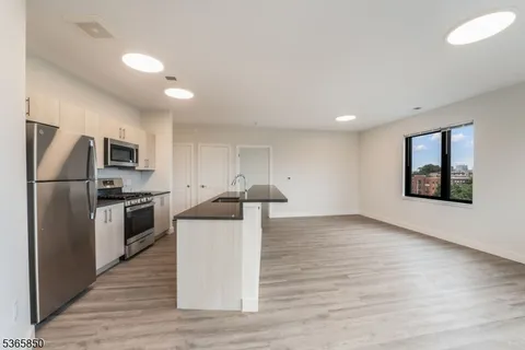 a kitchen with stainless steel appliances a refrigerator and a stove top oven