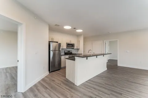 a view of kitchen with refrigerator stove microwave and cabinets