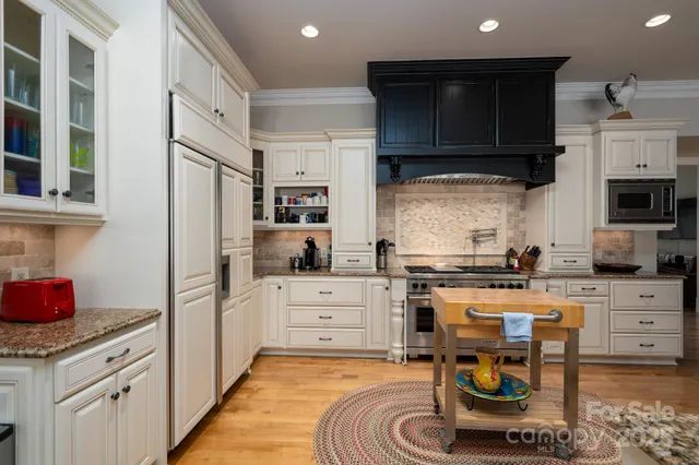 a kitchen with granite countertop a sink appliances and cabinets