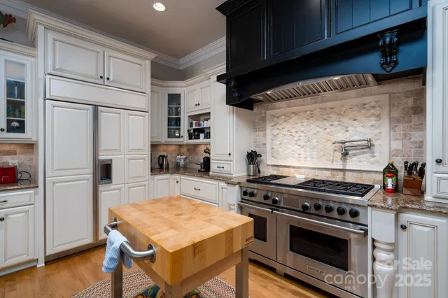 a kitchen with stainless steel appliances a stove a sink and cabinets