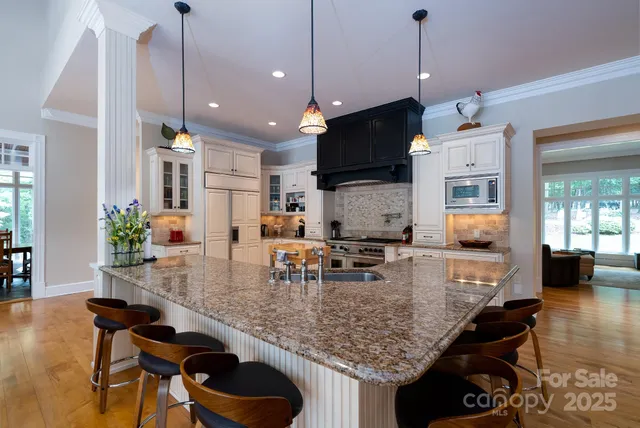 a kitchen with kitchen island granite countertop a stove a sink and a refrigerator