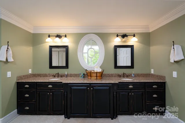 a bathroom with a granite countertop double vanity sink and a mirror