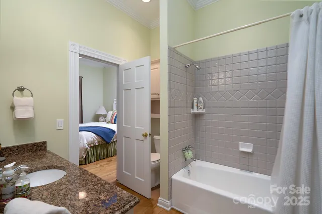 a bathroom with a granite countertop sink mirror bathtub and toilet
