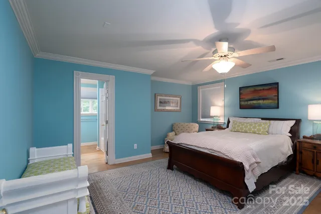 a bedroom with a bed chandelier and a window