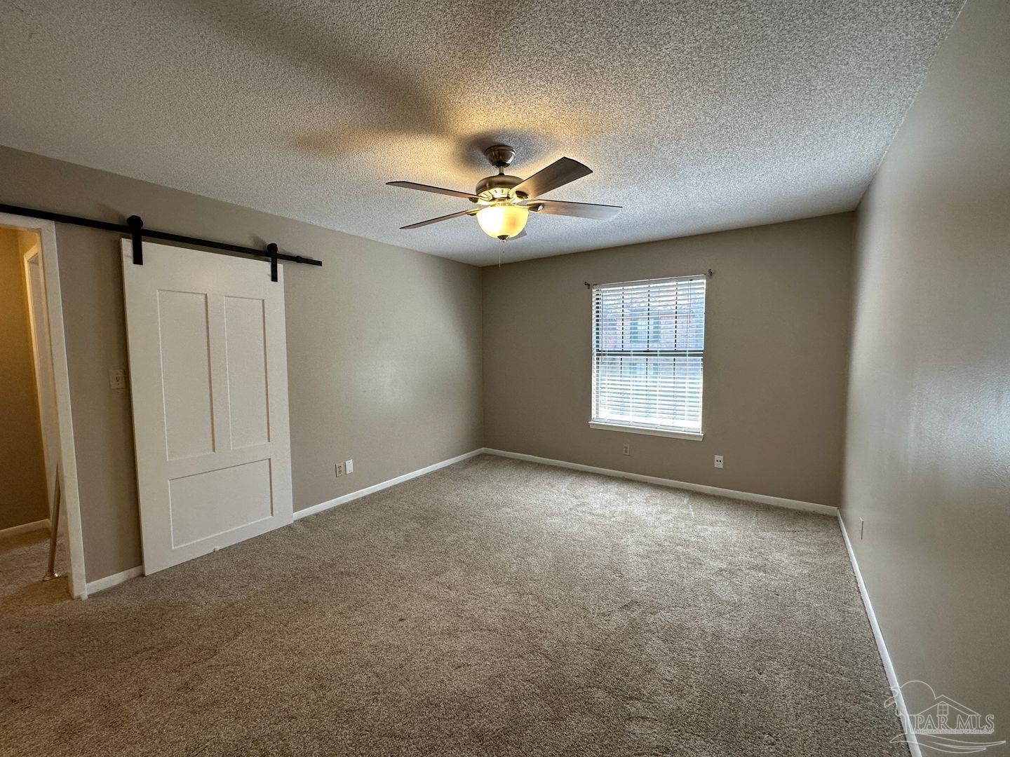 4831 East Olive Road, Unit 4D Pensacola, FL 32514 - Photo 13 of 17 an empty room with windows and fan