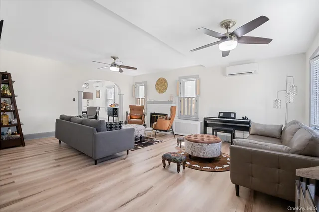a living room with furniture a fireplace and a ceiling fan