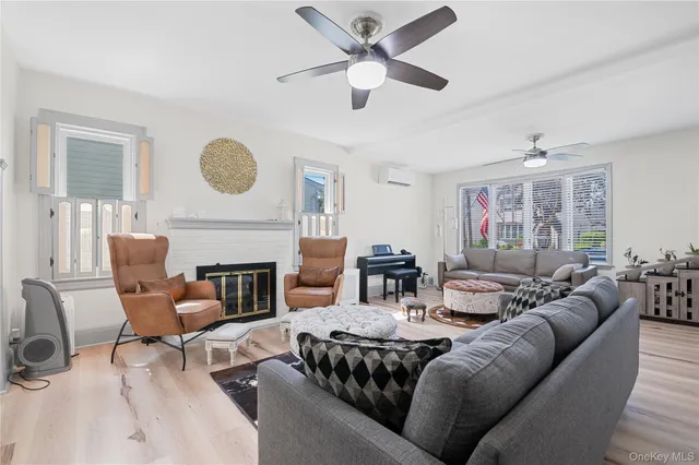 a living room with furniture a fireplace window and a ceiling fan