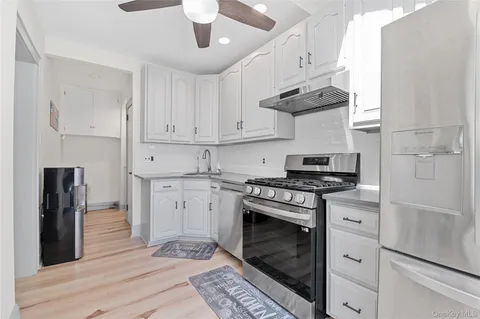 a kitchen with stainless steel appliances granite countertop a stove a refrigerator and a stove