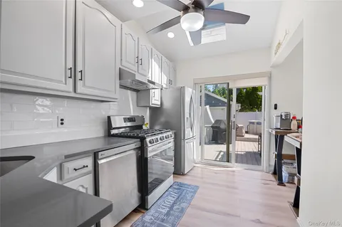 a kitchen with stainless steel appliances granite countertop a stove refrigerator and cabinets