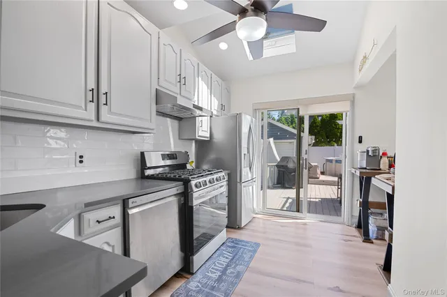 a kitchen with stainless steel appliances granite countertop a stove refrigerator and cabinets