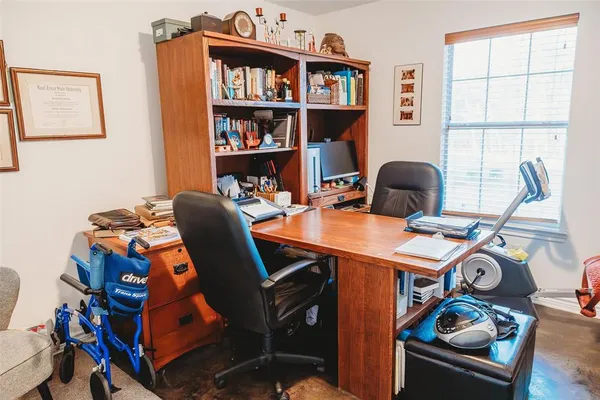 a work room with furniture a rug and a window