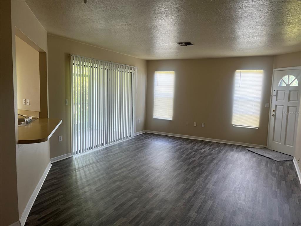 7266 Pond Circle Spring Hill, FL 34606 - Photo 3 of 11 an empty room with wooden floor and windows