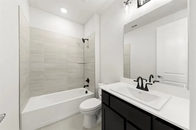 a bathroom with a sink a toilet a mirror a bathtub and shower