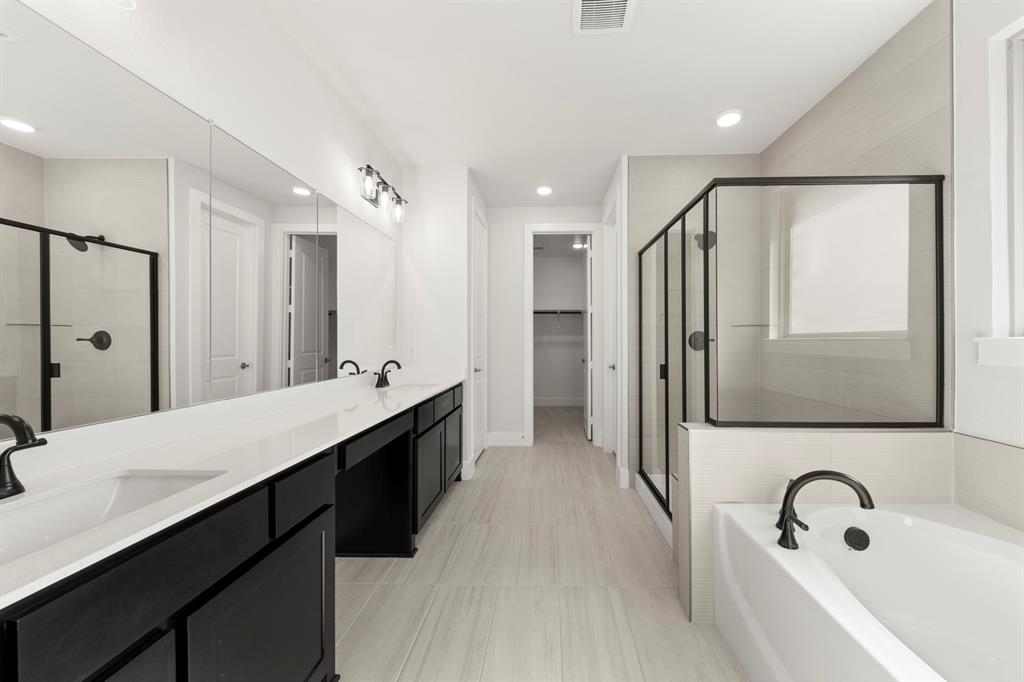 2917 Andesite Road McKinney, TX 75071 - Photo 15 of 27 a bathroom with a double vanity sink a mirror a bathtub and shower