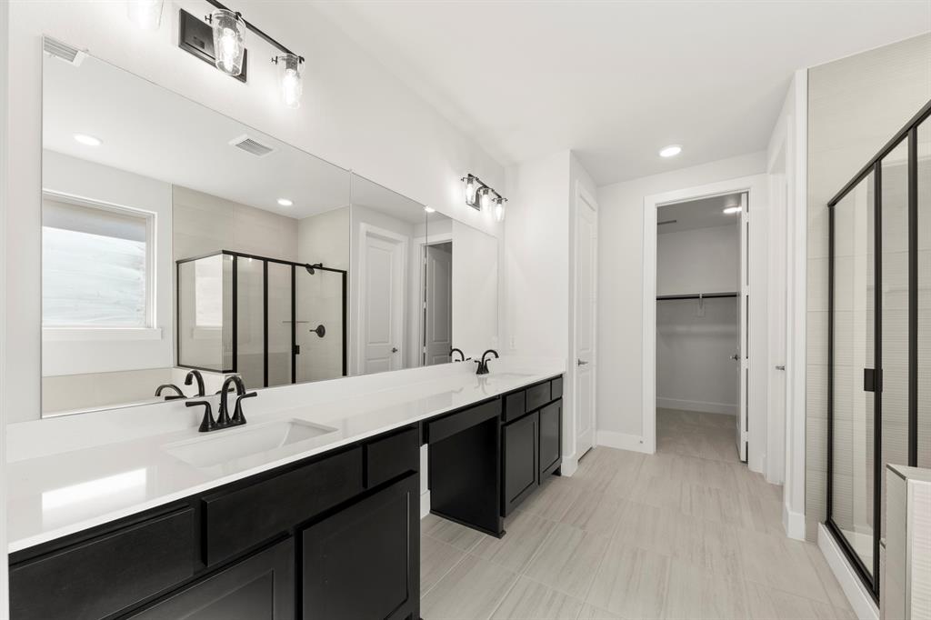 2917 Andesite Road McKinney, TX 75071 - Photo 16 of 27 a bathroom with a double vanity sink a mirror and shower