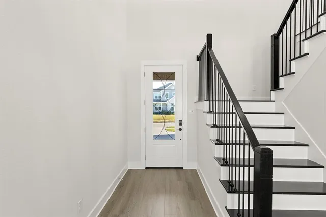 a view of staircase with wooden floor and white walls