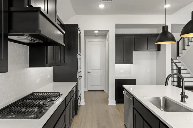 a kitchen with a sink and a stove top oven