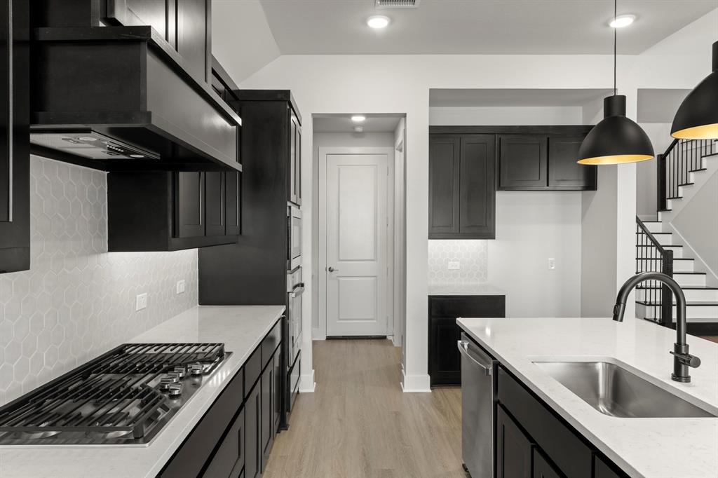 2917 Andesite Road McKinney, TX 75071 - Photo 8 of 27 a kitchen with a sink and a stove top oven