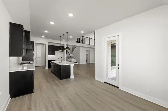 a kitchen with stainless steel appliances kitchen island wooden floors and refrigerator