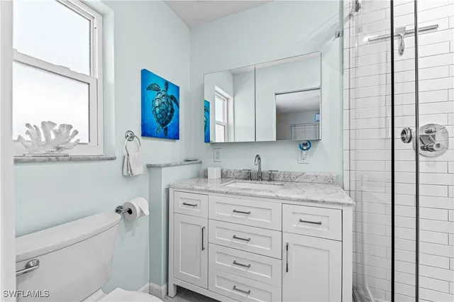 a bathroom with a granite countertop sink mirror and window