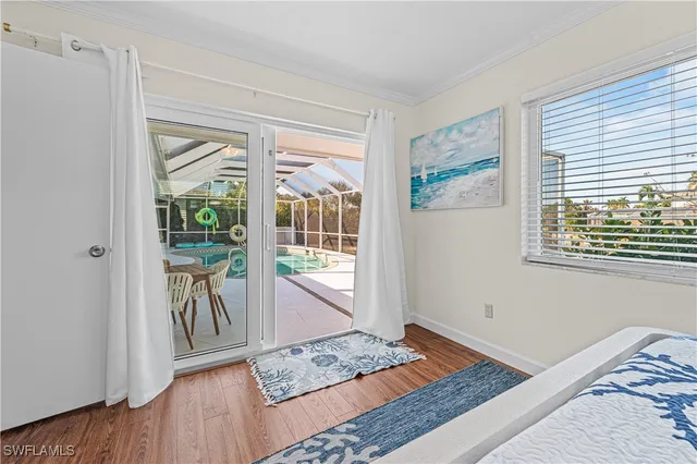 a view of a bedroom with wooden floor and a window