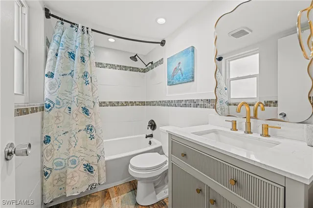 a bathroom with a sink toilet vanity and shower