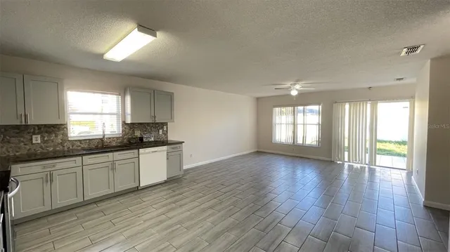 a large kitchen with hardwood floor and a window