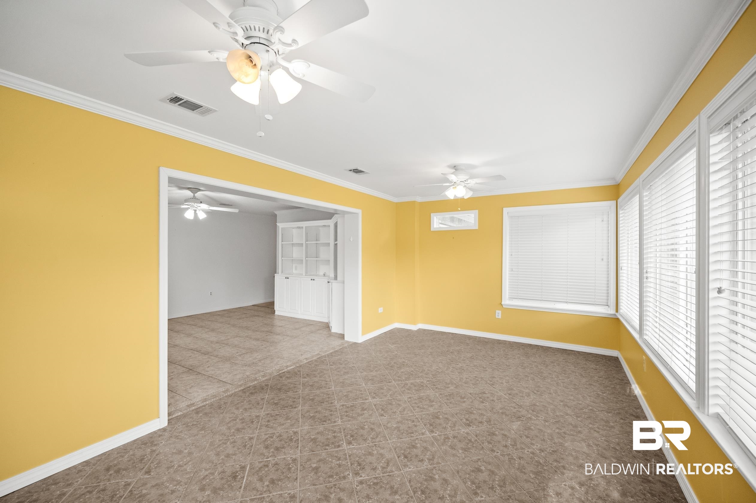 303 West Palm Avenue Foley, AL 36535 - Photo 11 of 32 Unfurnished room with light tile patterned flooring, crown molding, and ceiling fan