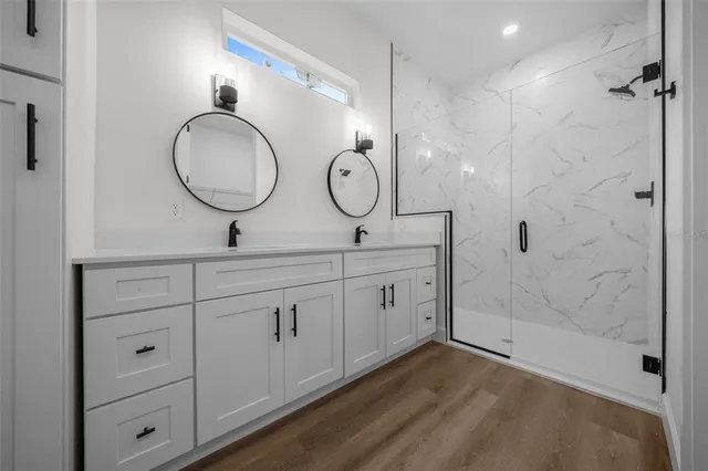 a bathroom with a double vanity sink mirror and shower