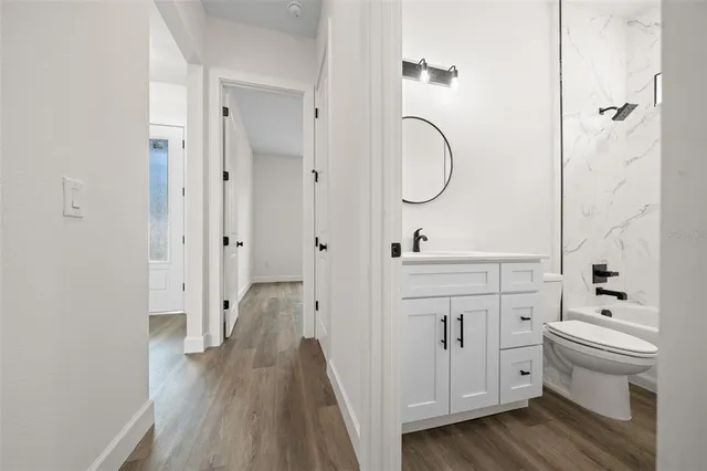 a bathroom with a granite countertop toilet a sink and a mirror