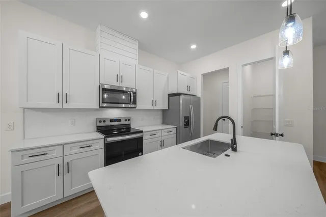 a kitchen with refrigerator a microwave and cabinets