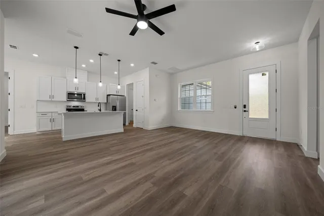 a view of a kitchen with an empty space and wooden floor