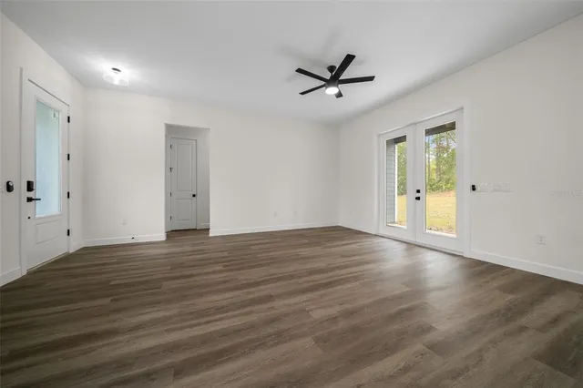 a view of empty room with wooden floor and window