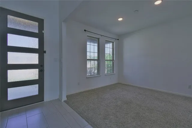 a view of a hallway with wooden floor and a bathroom
