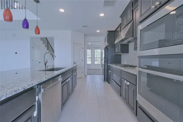 a kitchen with stainless steel appliances granite countertop a sink stove and refrigerator