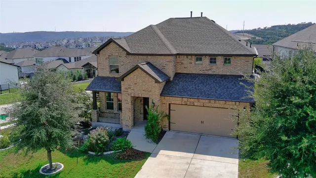 a aerial view of a house with a yard and potted plants