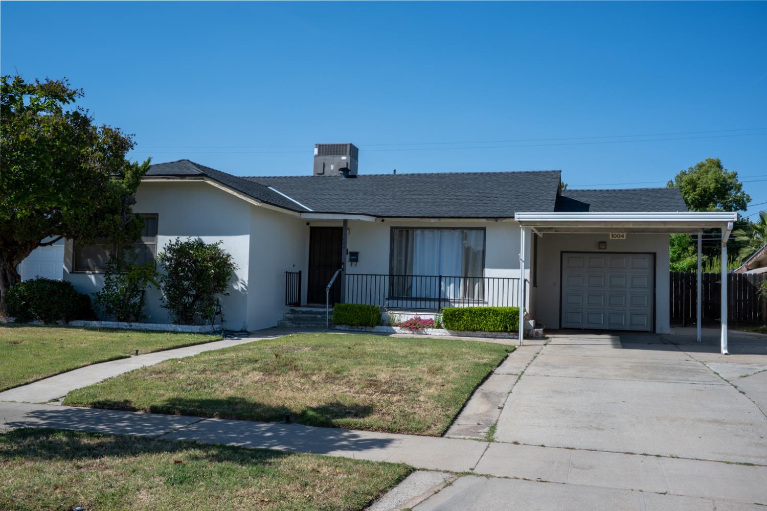 1004 West Pontiac Way Fresno, CA 93705 - Photo 1 of 34 a front view of a house with a yard and garage