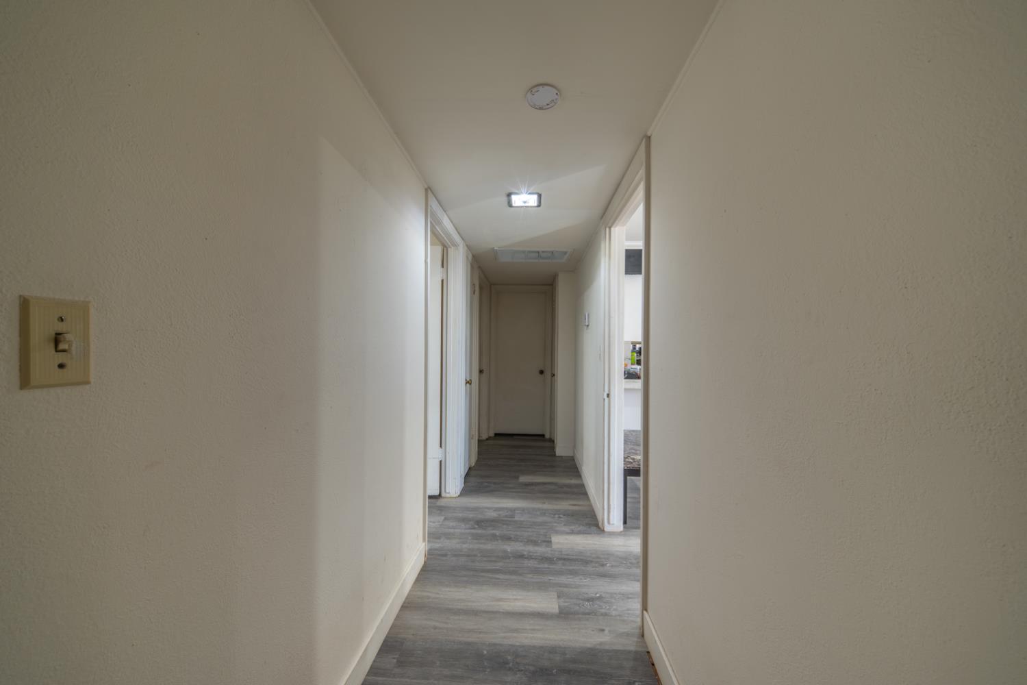 1004 West Pontiac Way Fresno, CA 93705 - Photo 13 of 34 a view of a hallway with wooden floor and a bathroom