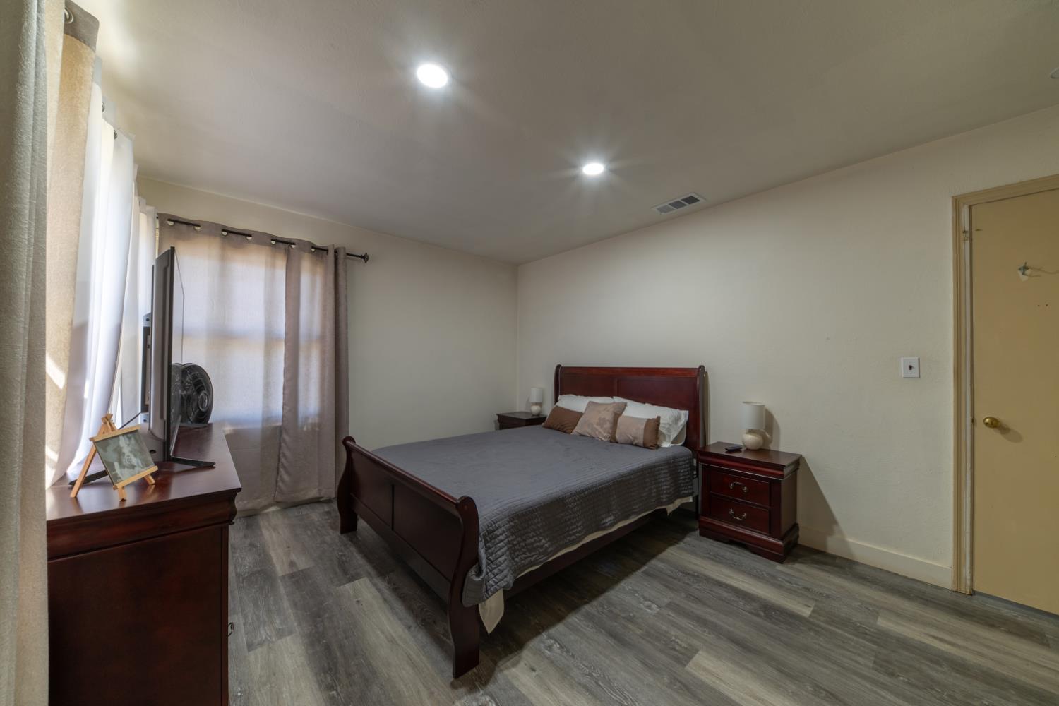 1004 West Pontiac Way Fresno, CA 93705 - Photo 16 of 34 a bedroom with a bed and wooden floor